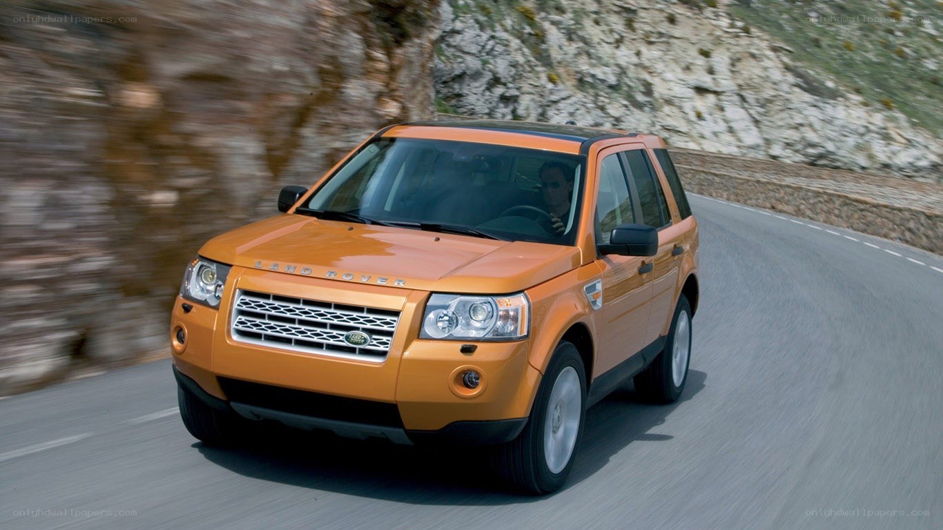 Orange Land Rover driving on road
