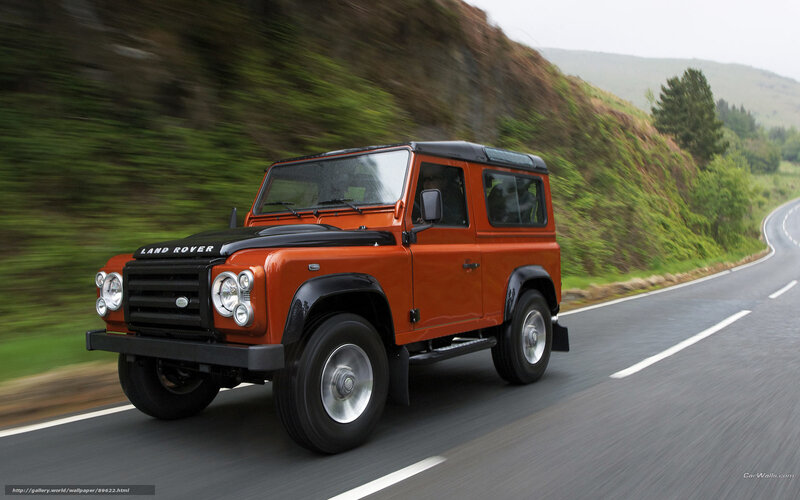 orange land rover driving on road