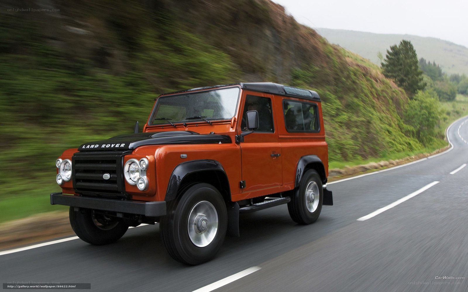 orange land rover driving on road
