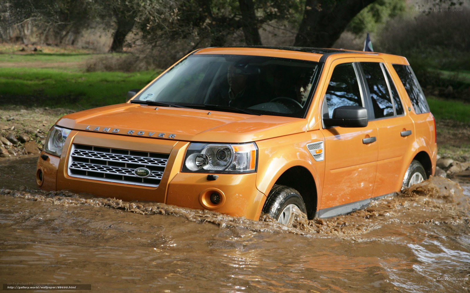 orange land rover in mud