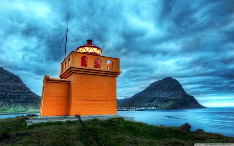 Orange Lighthouse on Coast — Dramatic