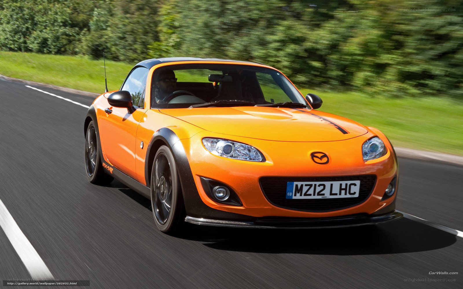 orange mazda miata in motion