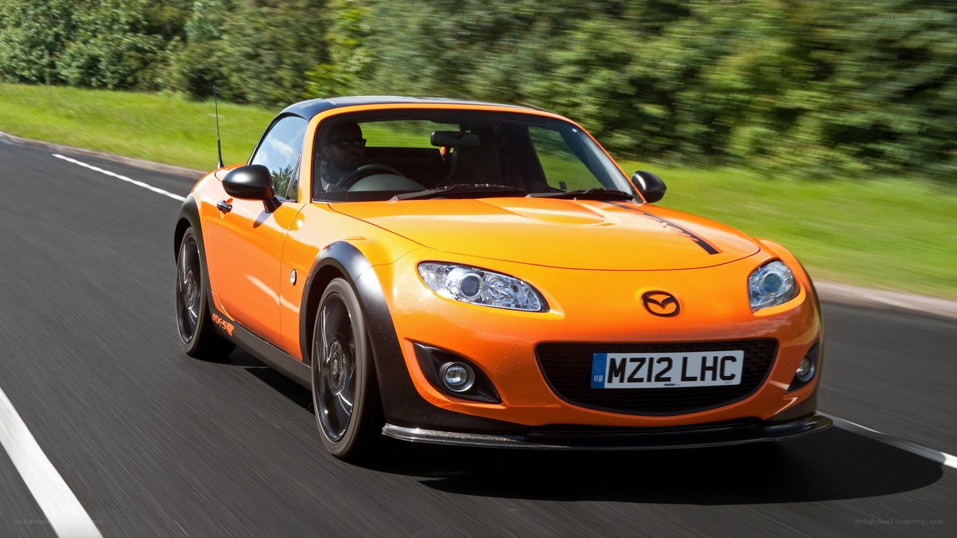 Orange Mazda MX-5 driving on road