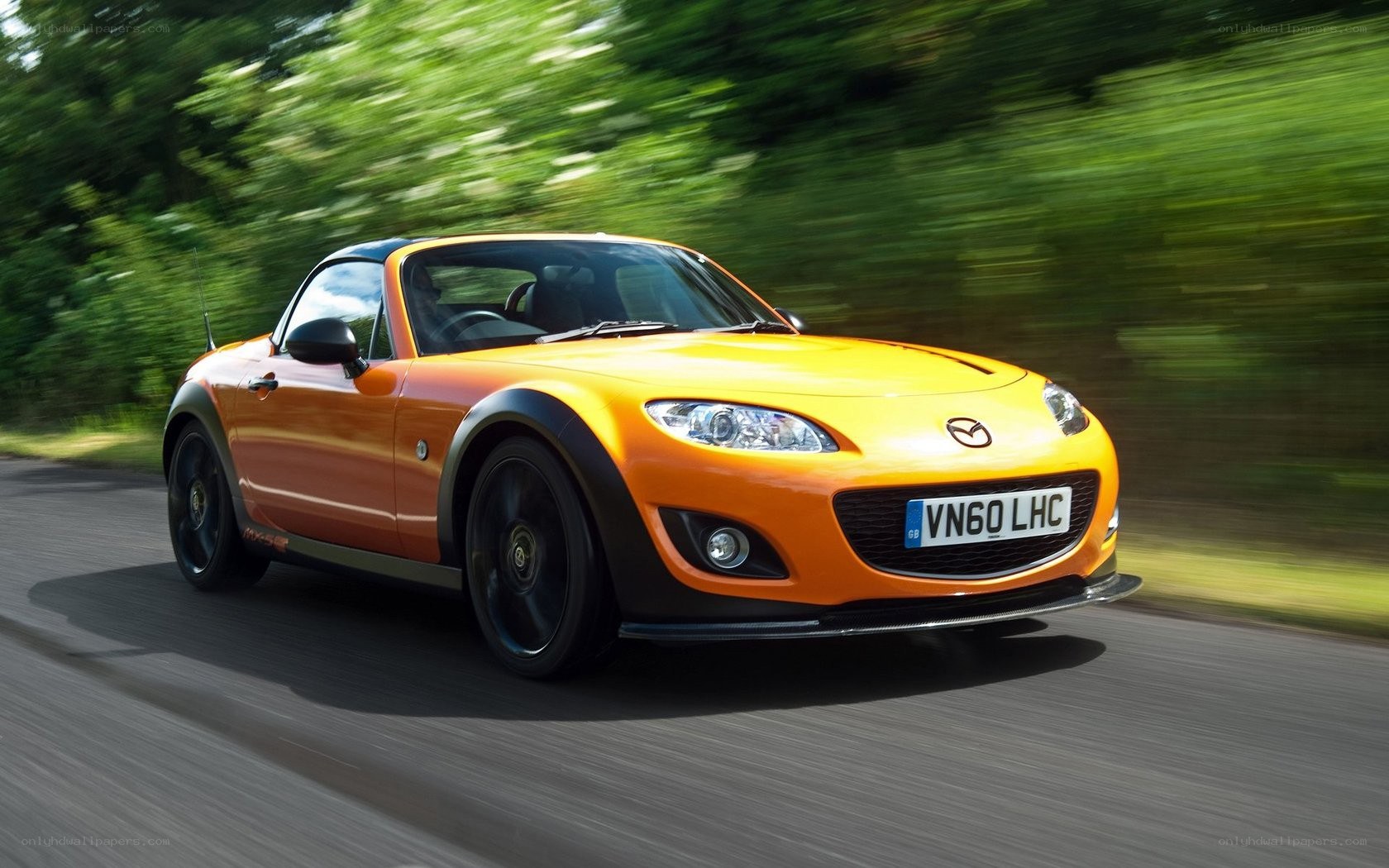Orange Mazda MX-5 driving on road