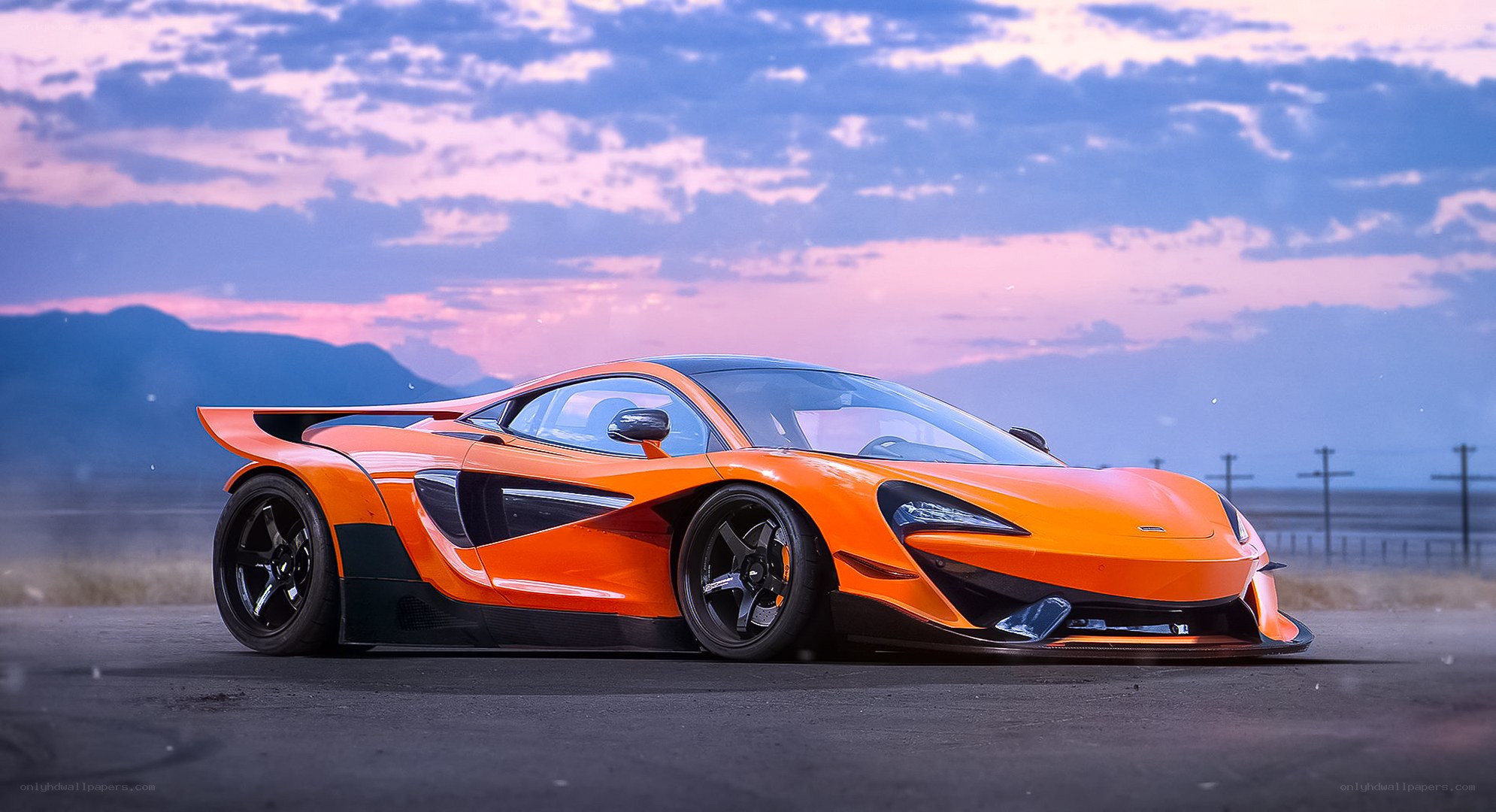 Orange McLaren supercar at sunset
