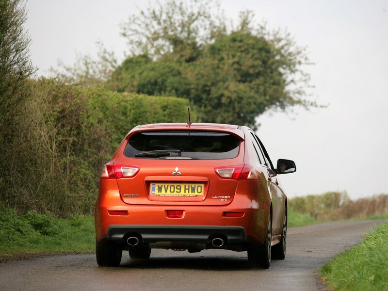 Orange Mitsubishi Lancer on country road