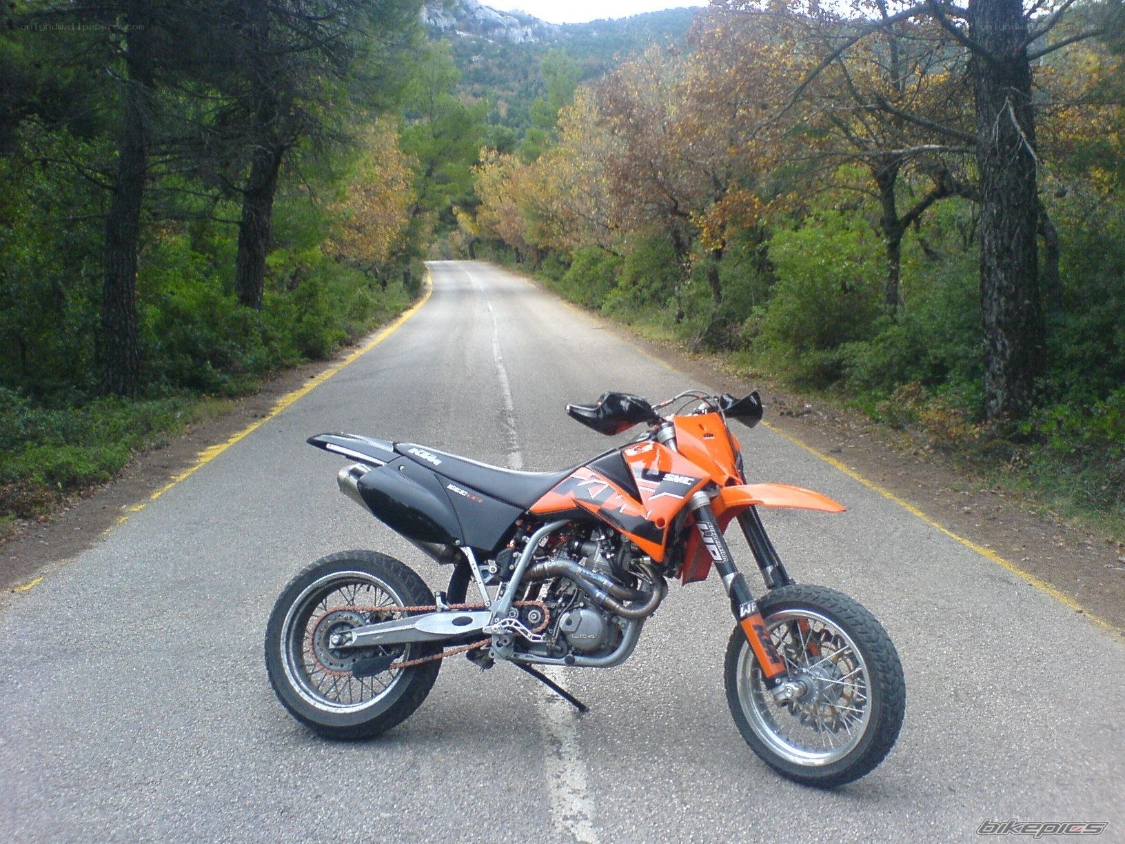 Orange motorcycle on a forest road