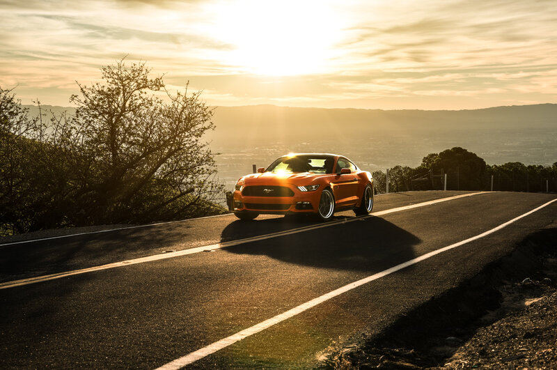 Orange Mustang on a winding road