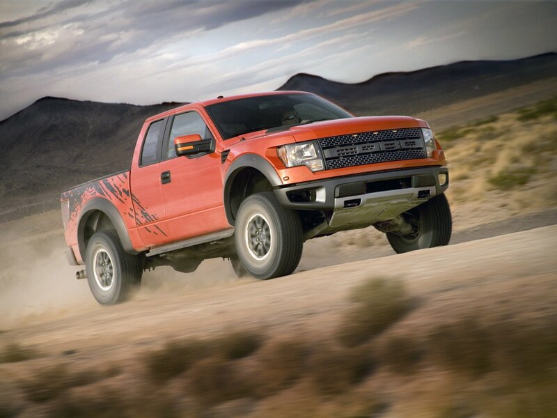 orange pickup truck on dirt road