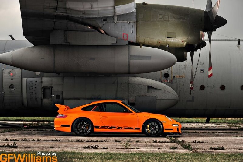 Orange Porsche GT3 RS and military plane