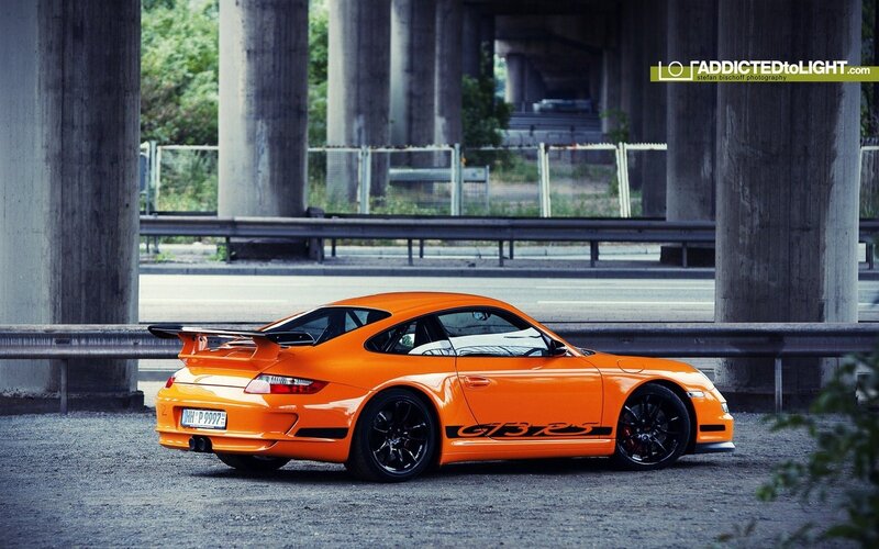 Orange Porsche GT3 RS under bridge