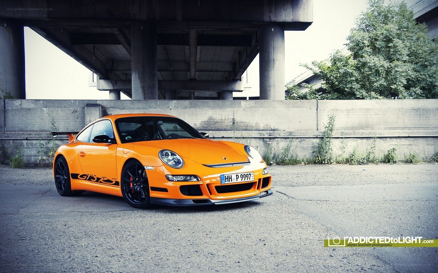 Orange Porsche GT3 RS under bridge