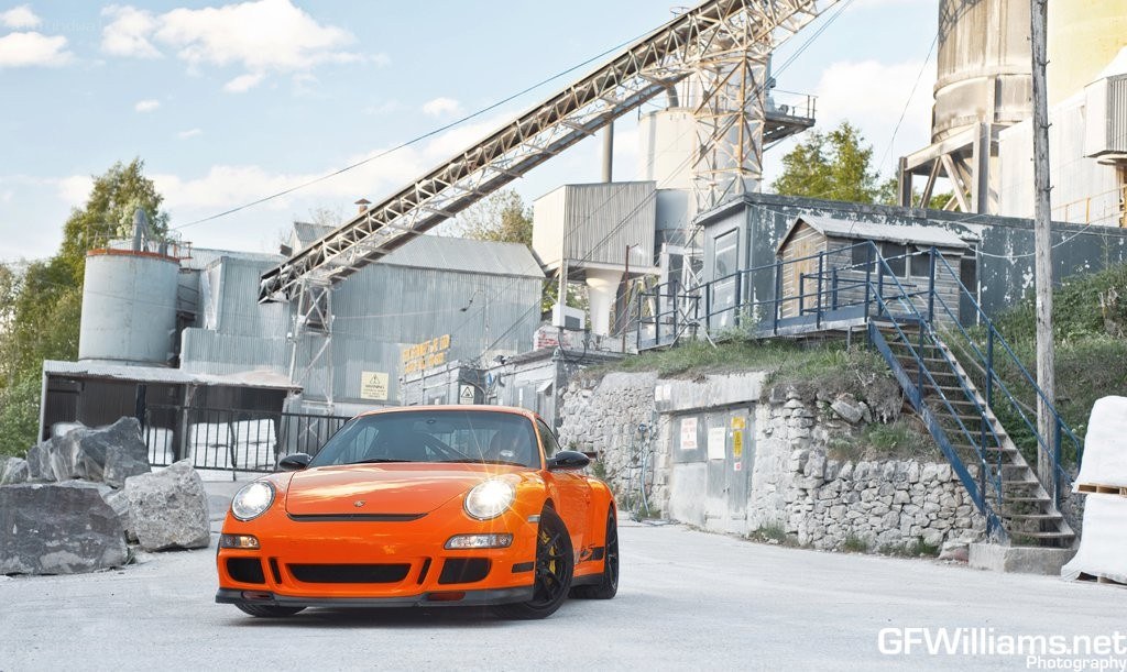 Orange Porsche in industrial setting