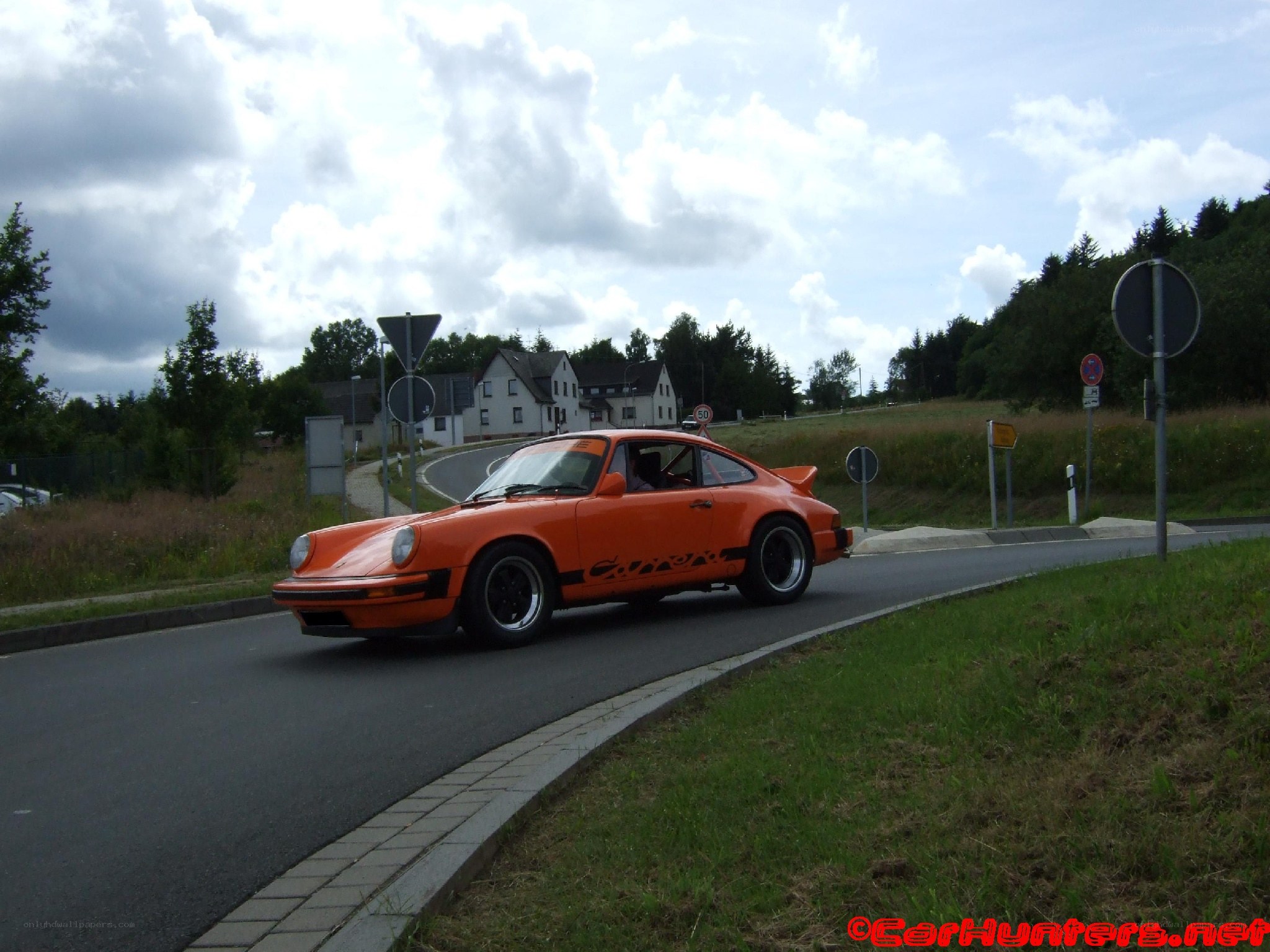 orange porsche on a road
