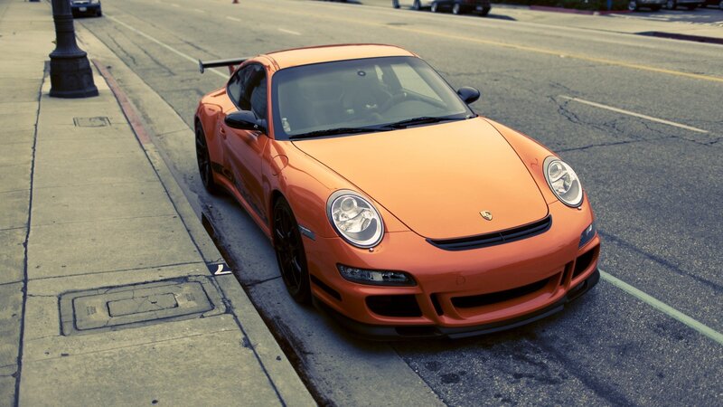 orange porsche on city street