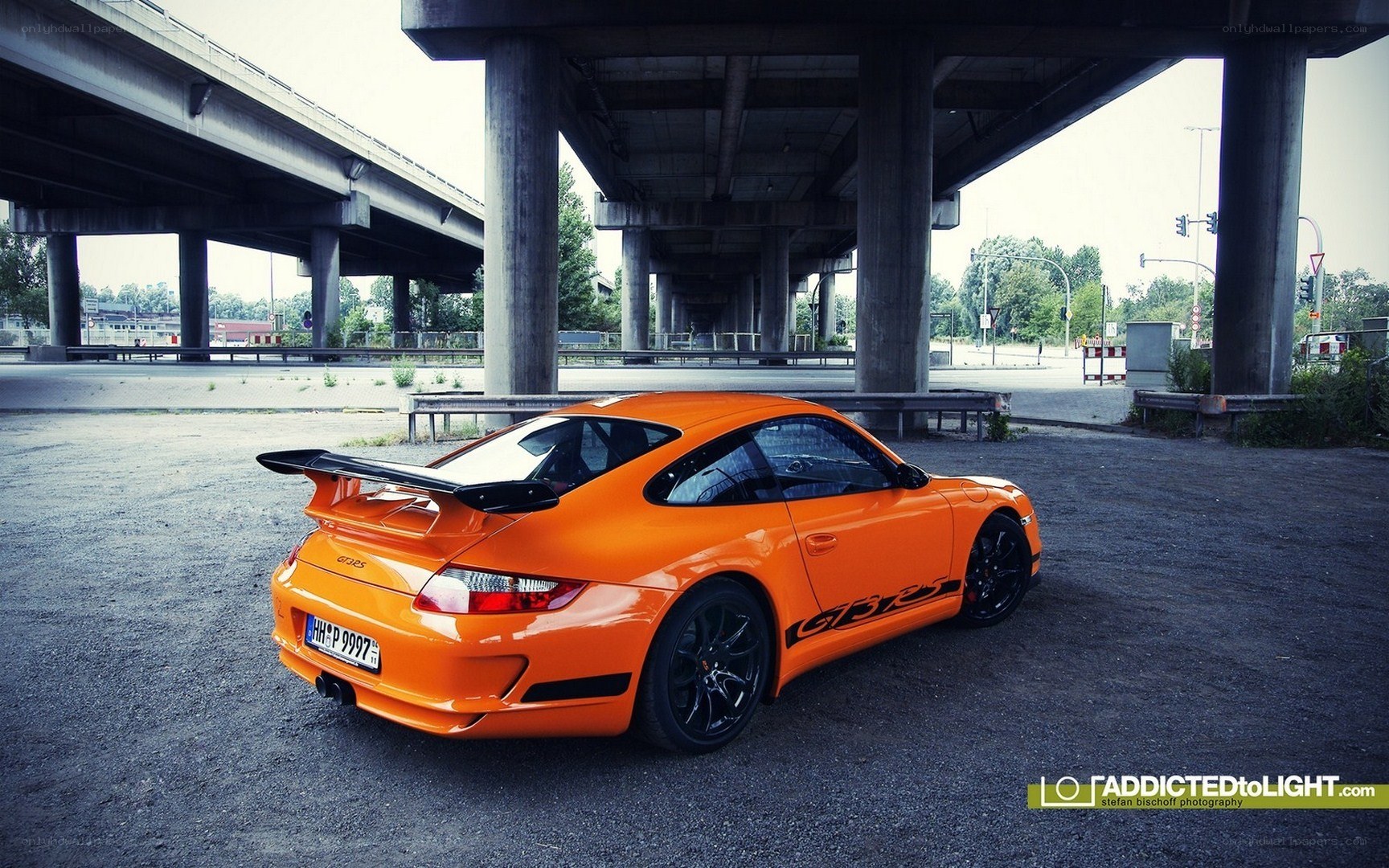Orange Porsche under highway