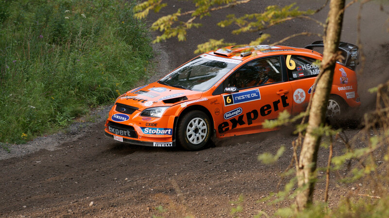 Orange rally car on dirt road