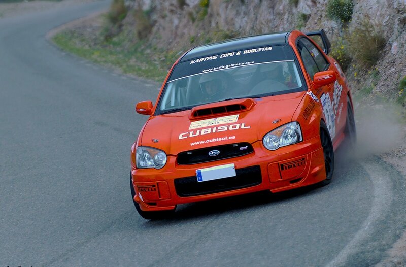 orange rally car on mountain road