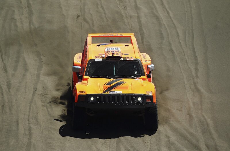 Orange rally car on sand dune