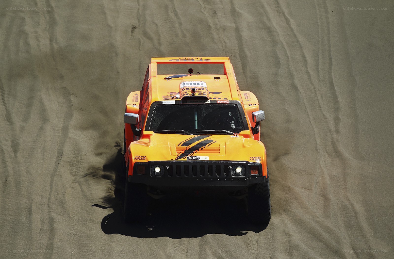 Orange rally car on sand dune