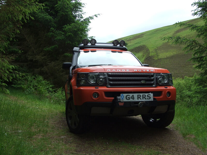 Orange Range Rover on a forest path