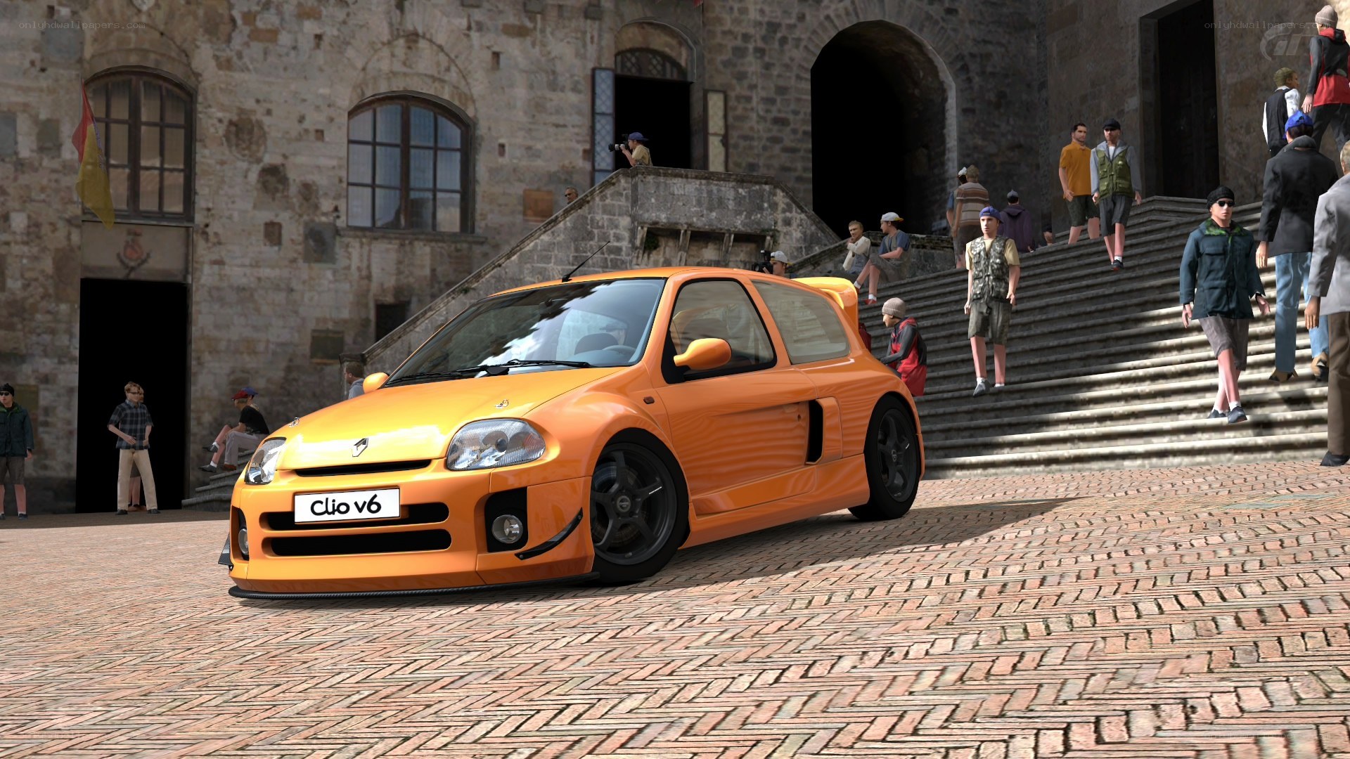 Orange Renault Clio V6 in a town square