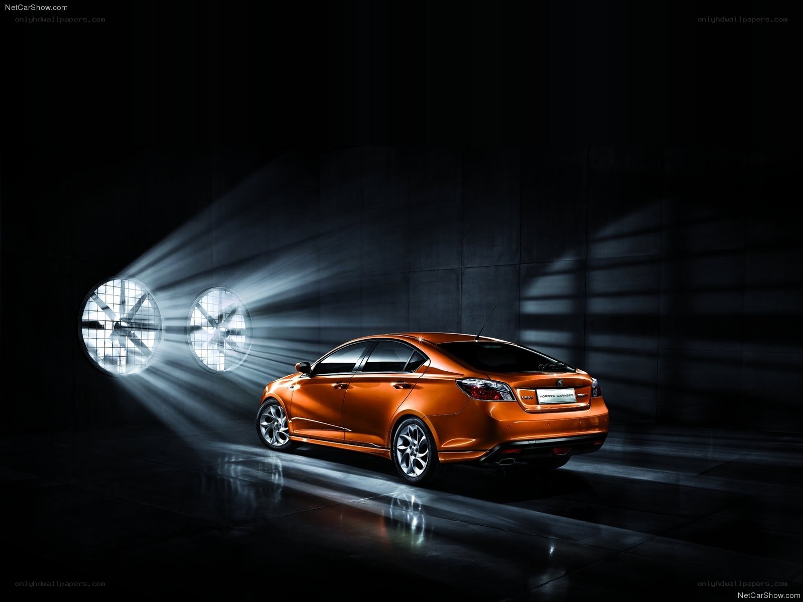 Orange sedan in studio spotlight