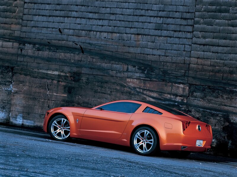 Orange sports car against brick wall