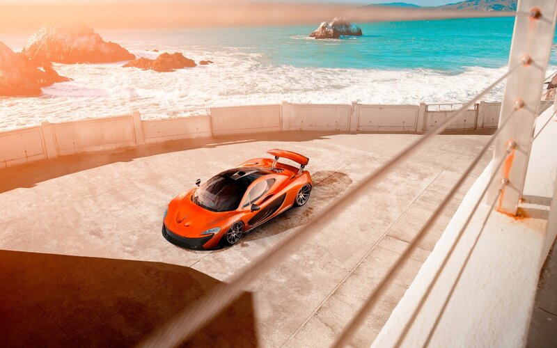 Orange sports car at coastal overlook