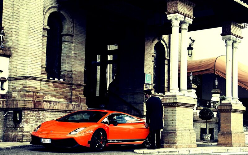 Orange sports car at hotel entrance
