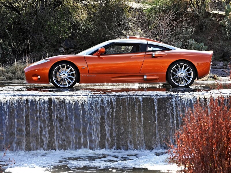 Orange sports car at waterfall