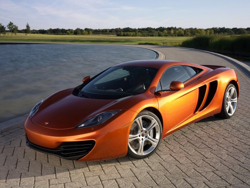 orange sports car by lake