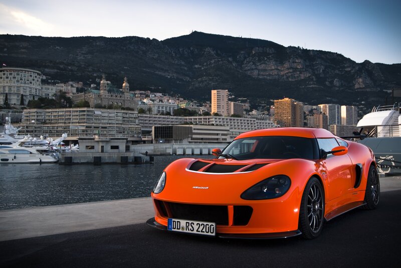 Orange sports car by the harbor