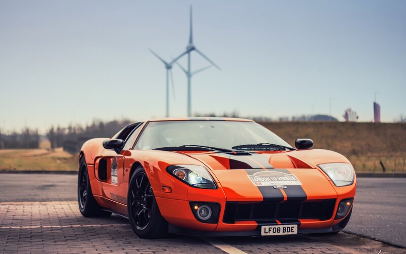 Orange Sports Car — Calm, Afternoon, Photograph, Wind Turbine, License Plate, Road, Black, White
