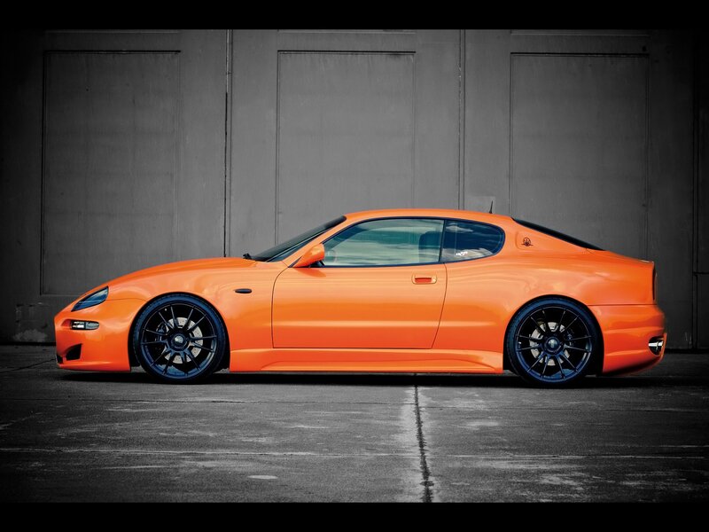 Orange Sports Car — Dramatic, Photograph, Black Wheels, Concrete Floor