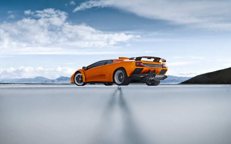 Orange Sports Car — Dramatic, Photograph, Mountains, Sky