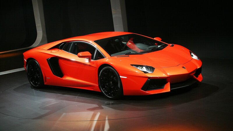 Orange Sports Car — Dramatic, Photograph, Showroom, Black Wheels
