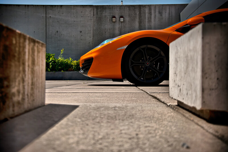 orange sports car in concrete lot