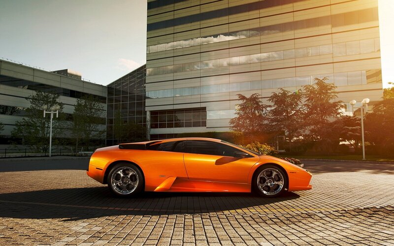 Orange sports car in front of building