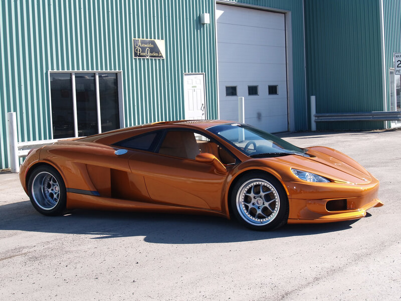 Orange sports car in front of building