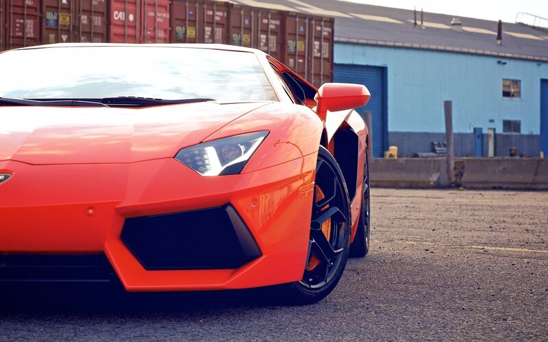 orange sports car in industrial area