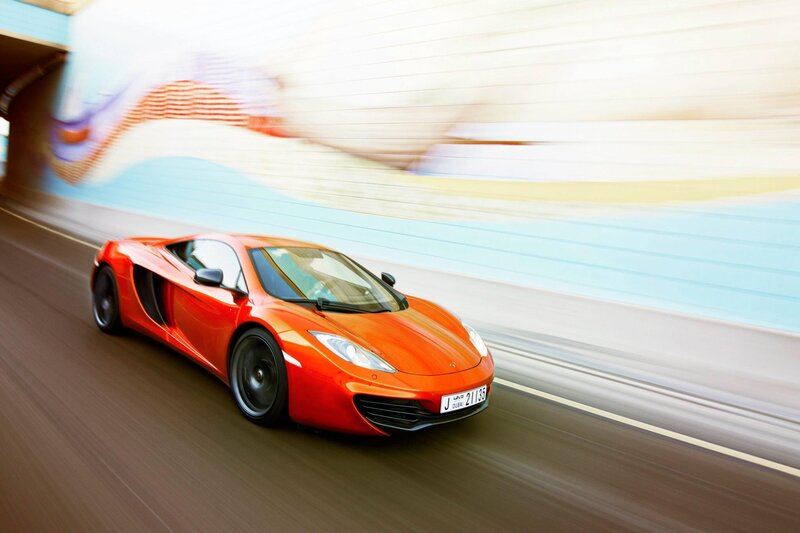 orange sports car in motion