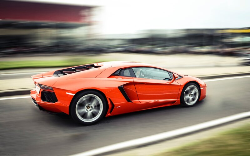 orange sports car in motion