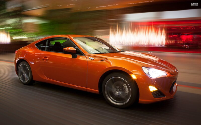 orange sports car in motion