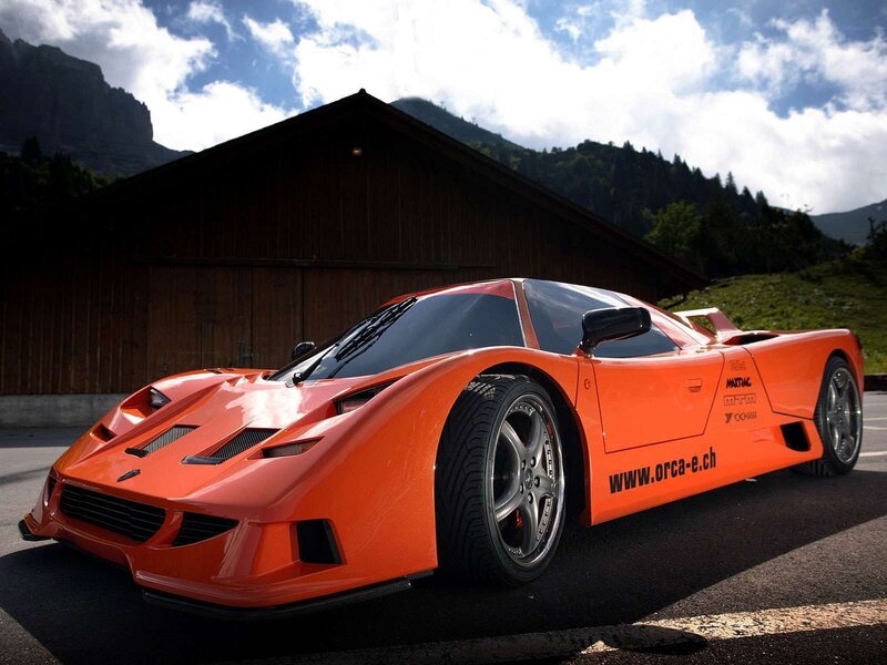 Orange sports car in mountain setting
