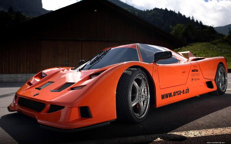 orange sports car in mountain setting