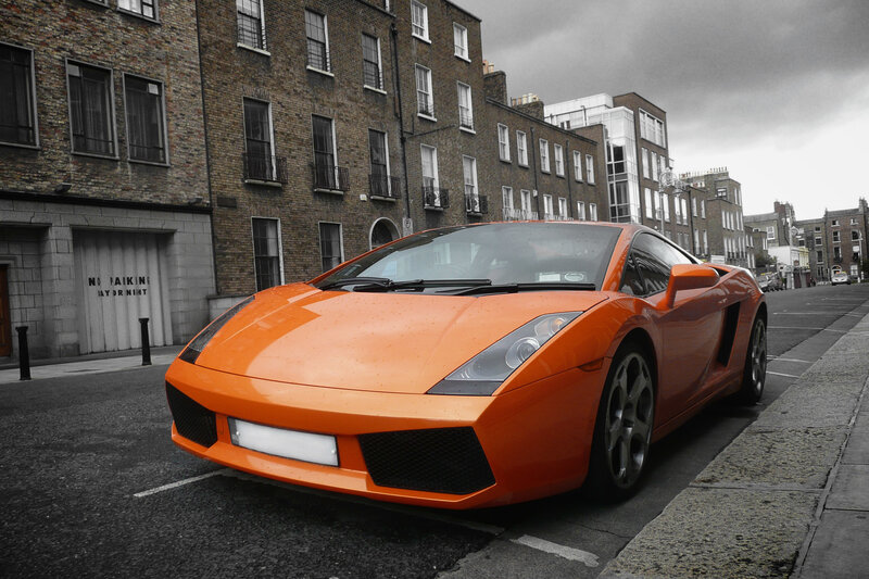 orange sports car on city street