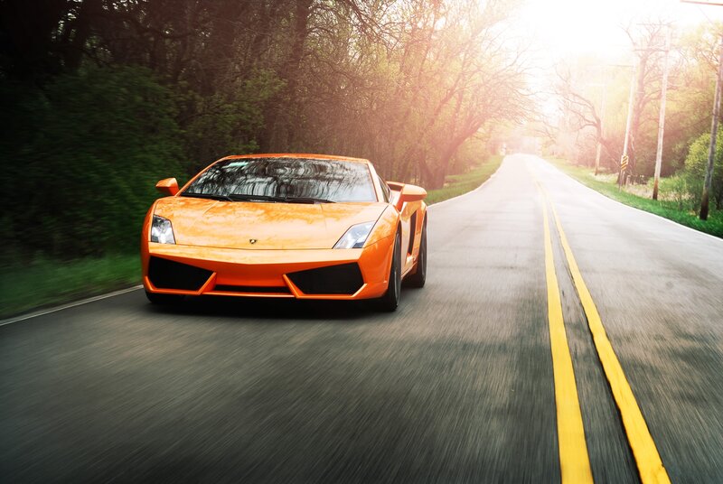 orange sports car on country road