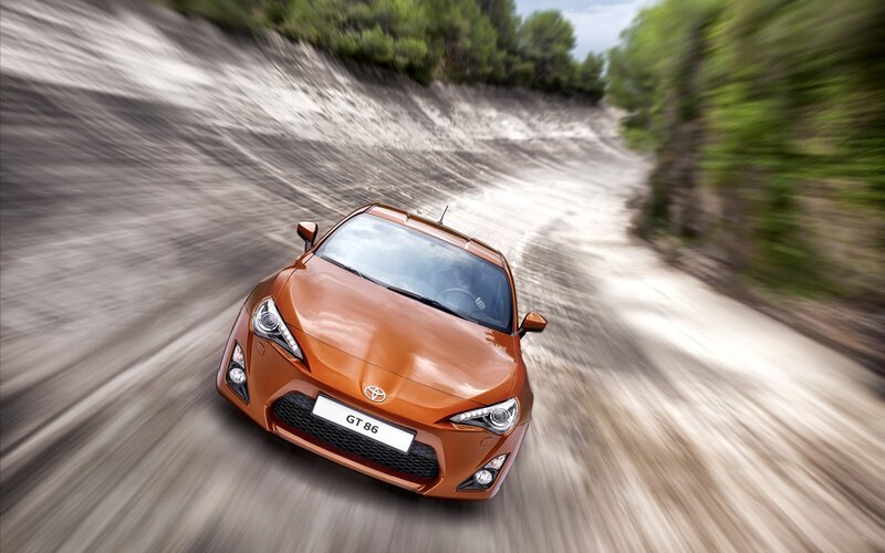 Orange sports car on dirt road