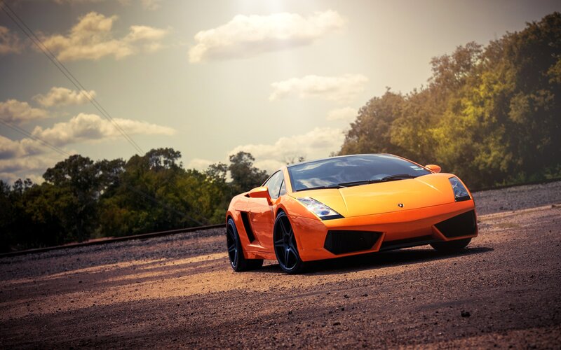 Orange sports car on gravel road